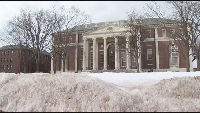 A man is charged with voyeurism after being caught allegedly video taping people in the school library bathroom.