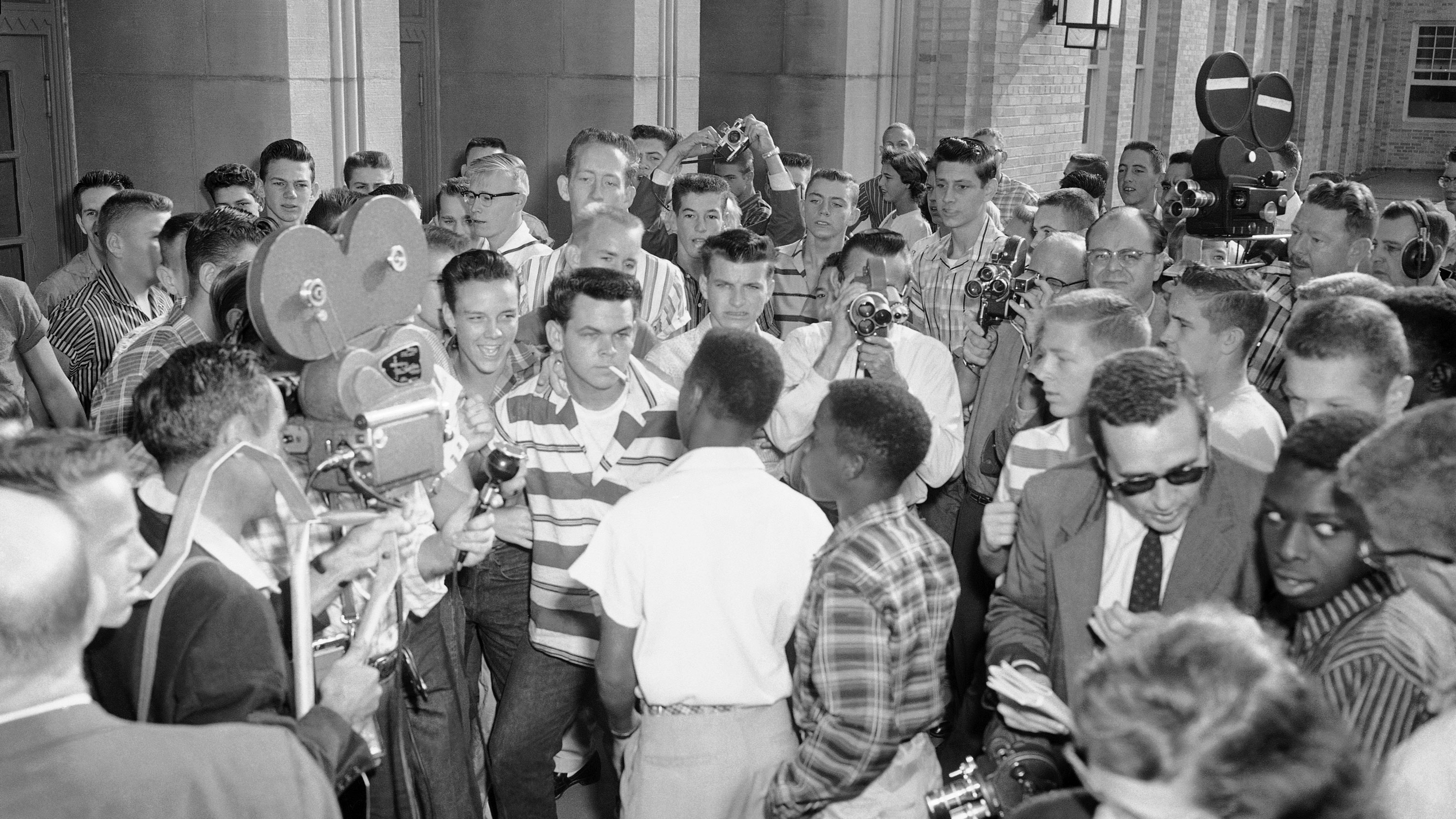 Defiant white students at Arkansas' North Little Rock High School block the doors of the school, denying access to six African-American students enrolled in the school Sept. 9, 1957. Moments later the African American students were shoved down a flight of stairs and onto the sidewalk, where city police broke up the altercation. 