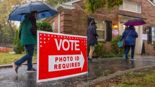 A red sign reading "vote: photo ID required"