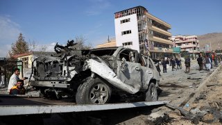 In this Nov. 13, 2019, file photo, Afghan security personnel remove a damaged vehicle after a car bomb attack in Kabul, Afghanistan.