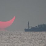 The sun, partially blocked by the moon, rises above the sea in Al Wakrah, Qatar, Dec. 26, 2019. Facebook and Twitter users were quick to draw comparisons between the reddened partial eclipse to "devil horns."
