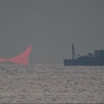 The sun, partially blocked by the moon, rises above the sea in Al Wakrah, Qatar, Dec. 26, 2019. Facebook and Twitter users were quick to draw comparisons between the reddened partial eclipse to "devil horns."