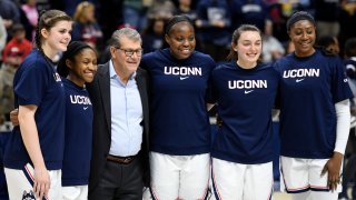 Connecticut seniors Kyla Irwin (25), Crystal Dangerfield (5), Evelyn Adebayo (14), Molly Bent (10), and Batouly Camara (32), stand with Connecticut head coach Geno Auriemma as they were honored before the NCAA college basketball game against Central Florida Saturday, Feb. 22, 2020, in Storrs, Connecticut.