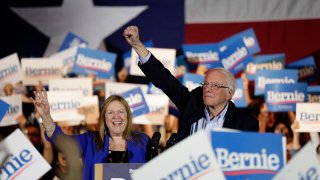 Democratic presidential candidate Sen. Bernie Sanders, I-Vt., right, with his wife Jane, raises his hand as he speaks during a campaign event in San Antonio, Saturday, Feb. 22, 2020. (AP Photo/Eric Gay)