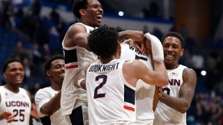 Connecticut's Christian Vital, top left, Connecticut's James Bouknight, front center, and Connecticut's Brendan Adams, back right, congratulate Connecticut's Isaiah Whaley at the end of an NCAA college basketball game against Central Florida, Wednesday, Feb. 26, 2020, in Hartford, Connecticut.