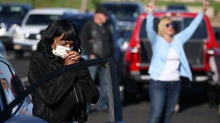 Keeping to safe social distance guidelines, worshipers pray at their own vehicles as they attend an outside drive-in Easter service at the Living Word church due to the coronavirus Sunday, April 12, 2020, in Mesa, Ariz.
