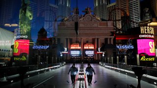 A lone worker wearing a mask cleans a pedestrian walkway devoid of the usual crowds as casinos and other business are shuttered due to the coronavirus outbreak in Las Vegas.
