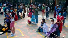 Visitors, wearing face masks, wait to enter the Disneyland theme park in Shanghai as it reopened, Monday, May 11, 2020.