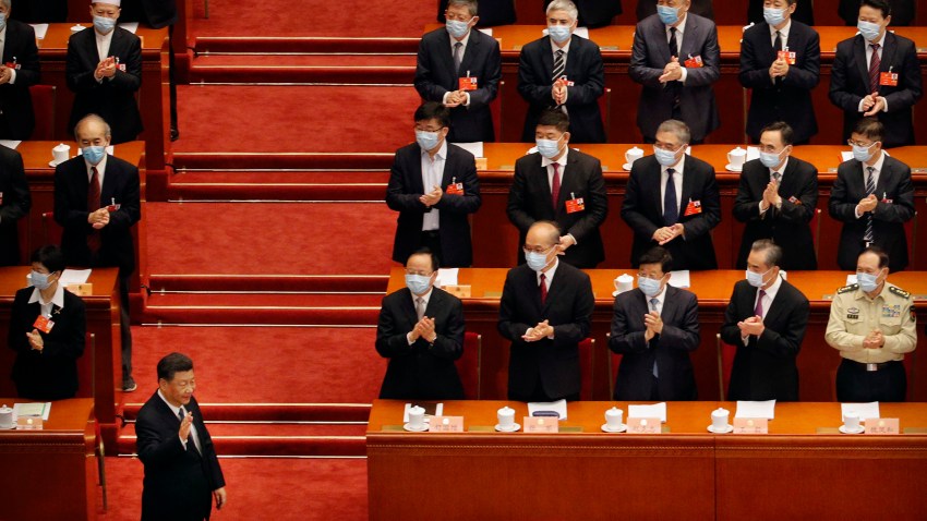 Chinese President Xi Jinping, left, gestures as he arrives for the opening session of the Chinese People's Political Consultative Conference (CPPCC) at the Great Hall of the People in Beijing, Thursday, May 21, 2020.