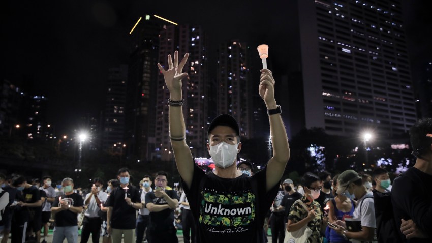 Participants gesture with five fingers, signifying the "Five demands - not one less" during a vigil for the victims of the 1989 Tiananmen Square Massacre at Victoria Park in Causeway Bay, Hong Kong, Thursday, June 4, 2020. China is tightening controls over dissidents while pro-democracy activists in Hong Kong and elsewhere try to mark the 31st anniversary of the crushing of the pro-democracy movement in Beijing's Tiananmen Square.
