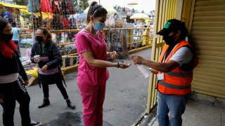 A shopper is given antibacterial gel as she enters a market