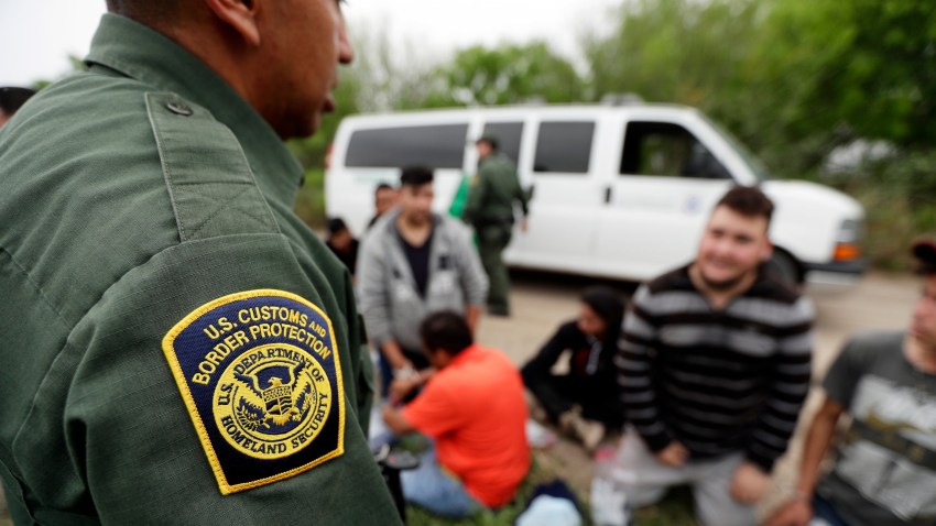 In this Thursday, March 14, 2019, file photo, a Border Patrol agent talks with a group suspected of having entered the U.S. illegally near McAllen, Texas.