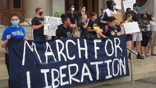 Protesters with a a march for liberation sign in honor of George Floyd