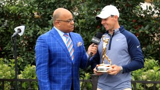 Rory McIlroy of Northern Ireland holds the new Players Championship trophy as he is interviewed by Mike Tirico after his one shot win as fans take photographs with their phones during the final round of The Players Championship on the Stadium Course at TPC Sawgrass on March 17, 2019 in Ponte Vedra Beach, Florida.