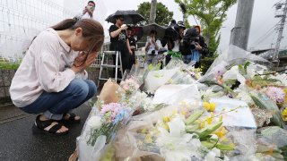 This July 19, 2019 picture shows a resident praying for victims of a fire which hit the Kyoto Animation studio building the day before, killing 37 people, in Kyoto.