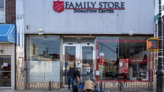 Pedestrians stop to look through donated clothing left outside a Salvation Army Donation Center