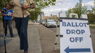 Ohio voters walk to drop off their ballots at the Board of Elections in Dayton, Ohio on April 28, 2020.