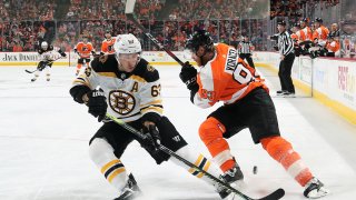 Brad Marchand of the Boston Bruins passes the puck between the legs of Jakub Voracek of the Philadelphia Flyers on March 10, 2020 at the Wells Fargo Center in Philadelphia.