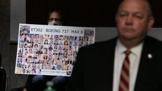 Michael Stumo holds a sign displaying photographs of the those killed in the March 10, 2019, crash of Ethiopian Airlines Flight 302 as Federal Aviation Administration (FAA) chief Steve Dickson testifies before a Senate panel examining the safety certification of jetliners on June 17, 2020 in Washington, DC.