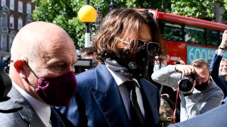 Johnny Depp, right, wearing a protective mask arrives at the Royal Court of Justice, in London, Tuesday, July 7, 2020. Johnny Depp is suing a tabloid newspaper for libel over an article that branded him a "wife beater."