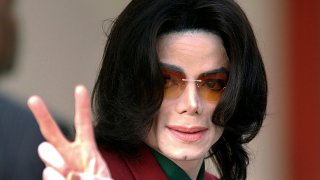 In this Thursday, March 17, 2005, file photo, pop star Michael Jackson acknowledges his fans as he arrives at the Santa Barbara County Courthouse, in Santa Maria, Calif.