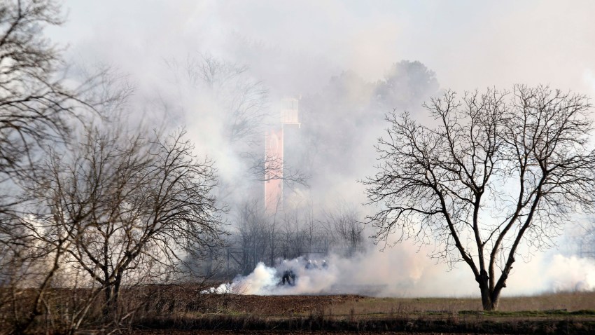 Greek riot police police is seen through smoke during clashes at the Greek-Turkish border in Kastanies, Evros region, on Friday, March 6, 2020. Thousands of refugees and other asylum-seekers have tried to enter Greece from the land and sea in the week since Turkey declared its previously guarded gateways to Europe open.