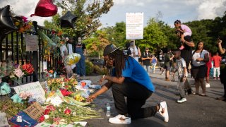 In this June 14, 2020, file photo, a man kneels at the memorial for Rayshard Brooks in Atlanta, Georgia.
