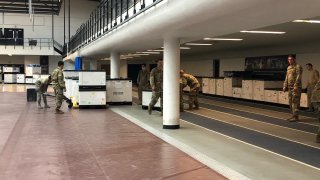 national guard soldiers move medical supplies into the field house at southern Connecticut state university