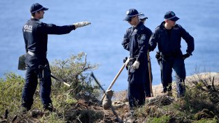 Police search a headland in Sydney, Tuesday, May 12, 2020, following an arrest in relation to the death of a man in 1998. More than 30 years after American mathematician Scott Johnson died after falling off a cliff in Sydney, a man has been charged with his death in an apparent gay hate crime that police believe was one of many over several decades in Australia's largest city.