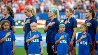 United States players Tierna Davidson, Lindsey Horan, Julie Ertz, Abby Dahlkemper, and Kelley O'Hara stand with their jerseys turned inside out during the playing of the national anthem before a SheBelieves Cup women's soccer match against Japan, Wednesday, March 11, 2020 at Toyota Stadium in Frisco, Texas.