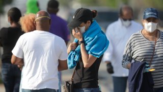 A person pauses as she gets in line at a walk-up coronavirus testing site during the COVID-19 pandemic, Saturday, April 18, 2020, at the Urban League of Broward County in Fort Lauderdale, Fla.