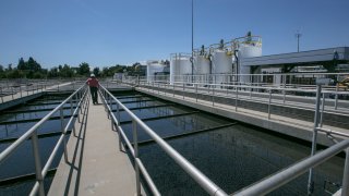 In this May 20, 2015, file photo, Michael Ruiz, shift superintendent for Wastewater Treatment II, at the Donald C. Tillman Water Reclamation Plant tours the Secondary Treatment Clarifiers tanks at the Los Angeles Sanitation plant where millions of gallons of wastewater are purified each day in Van Nuys, Calif.