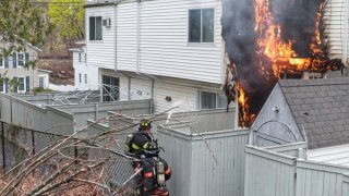 flames shoot out from the back of a housing complex in Danbury