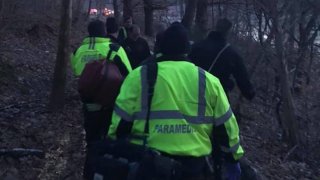 rescuers carry victim through the woods