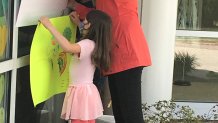 The nieces of Jerry Blais, of Windsor Locks, hold up signs during a window visit at Gaylord Hospital.