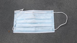 NEW YORK, NEW YORK – JULY 07: A used surgical face mask is seen on the sidewalk in midtown as New York City moves into Phase 3 of re-opening following restrictions imposed to curb the coronavirus pandemic on July 7, 2020. Phase 3 permits the reopening of nail and tanning salons, tattoo parlors, spas and massages, dog runs and numerous other outdoor activities. Phase 3 is the third of four-phased stages designated by the state. (Photo by Noam Galai/Getty Images)