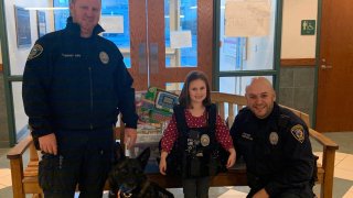 young girl standing with Wethersfield police after donating toys