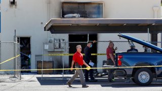 Fire investigators stand outside the Arizona Democratic Party headquarters Friday, July 24, 2020, in Phoenix. Fire investigators are looking into the cause of an early morning blaze that destroyed part of the Arizona and Maricopa County Democratic Party headquarters Friday.
