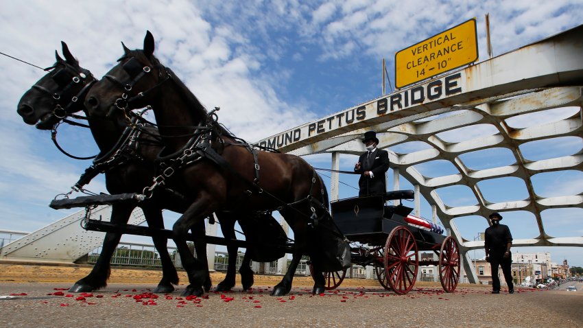 The casket of Rep. John Lewis moves over the Edmund Pettus Bridge by horse drawn carriage during a memorial service for Lewis, Sunday, July 26, 202
