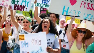 Demonstrators hold signs during a protest against Georgia's "heartbeat" abortion bill outside of the Georgia State Capitol building in Atlanta, Georgia, U.S., on Saturday, May 25, 2019. People gathered to protest the state's recently passed House Bill 481, which would ban abortion after a doctor can detect a fetal heartbeat usually around the sixth week of pregnancy.