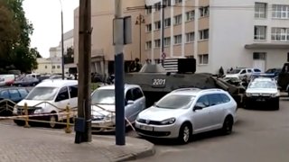In this image take from video, the scene as streets are closed off, with an armored security vehicle and police car, right, after an armed man seized a bus and took some 20 people hostage in the city centre of Lutsk, some 400 kilometers (250 miles) west of Kyiv, Ukraine on Tuesday July 21, 2020.