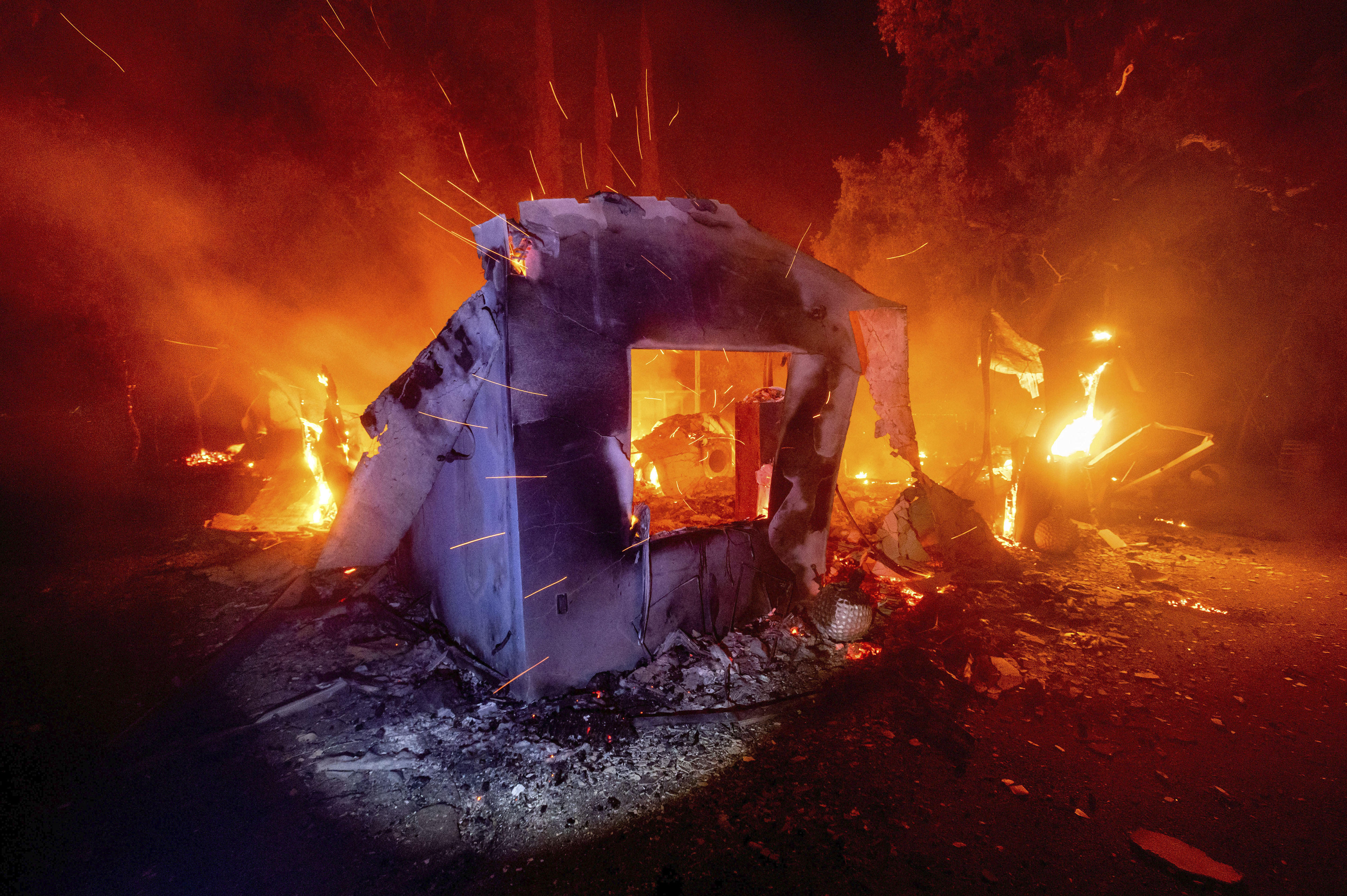 Flames from the LNU Lightning Complex fires consume a home in unincorporated Napa County, Calif., on Wednesday, Aug. 19, 2020. Fire crews across the region scrambled to contain dozens of wildfires sparked by lightning strikes.