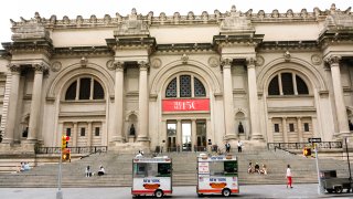 People sit outside on the steps of the Metropolitan Museum of Art