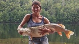 a woman holding a massive fish