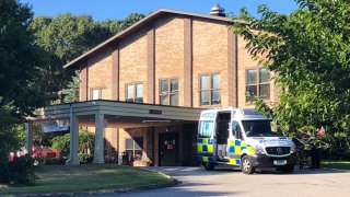 an ambulance sits outside Three Rivers Nursing Home in Norwich