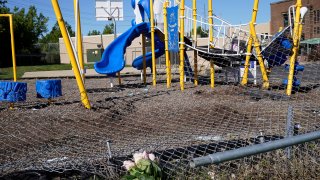 This photo shows flowers placed as a memorial at a playground where a car driven by a slain Cleveland police detective came to rest after being shot the night before in Cleveland