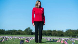 Speaker of the House Nancy Pelosi, D-Calif., stands amid flags planted on the National Mall as a memorial to the more than 200,000 Americans who have died due to the coronavirus, Sept. 22, 2020, in Washington, D.C.