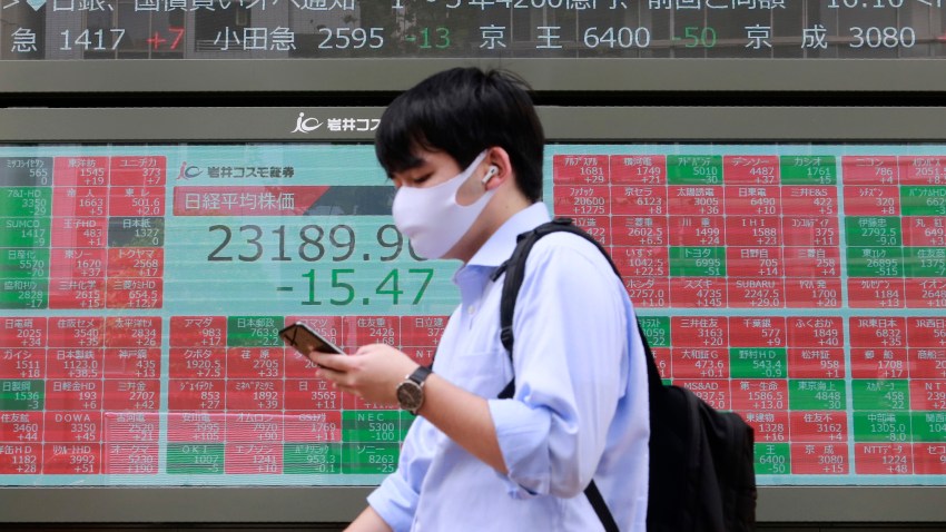 A man walks by an electronic stock board of a securities firm in Tokyo, Monday, Sept. 7, 2020. Asian stock markets were mixed Monday after Wall Street turned in its biggest weekly decline in more than two months.