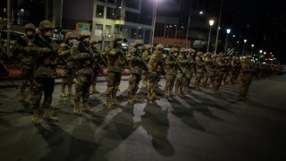Military officers wearing facemasks stand guard during the start of a police patrol ahead of general elections on October 17, 2020 in La Paz, Bolivia.