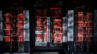 This photo taken on November 12, 2020, shows stocked up chairs inside a closed restaurant on the Champs-Elysees avenue in Paris.